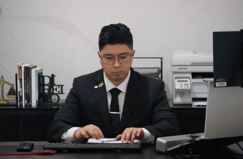Lucas Souza de terno analisando documentos